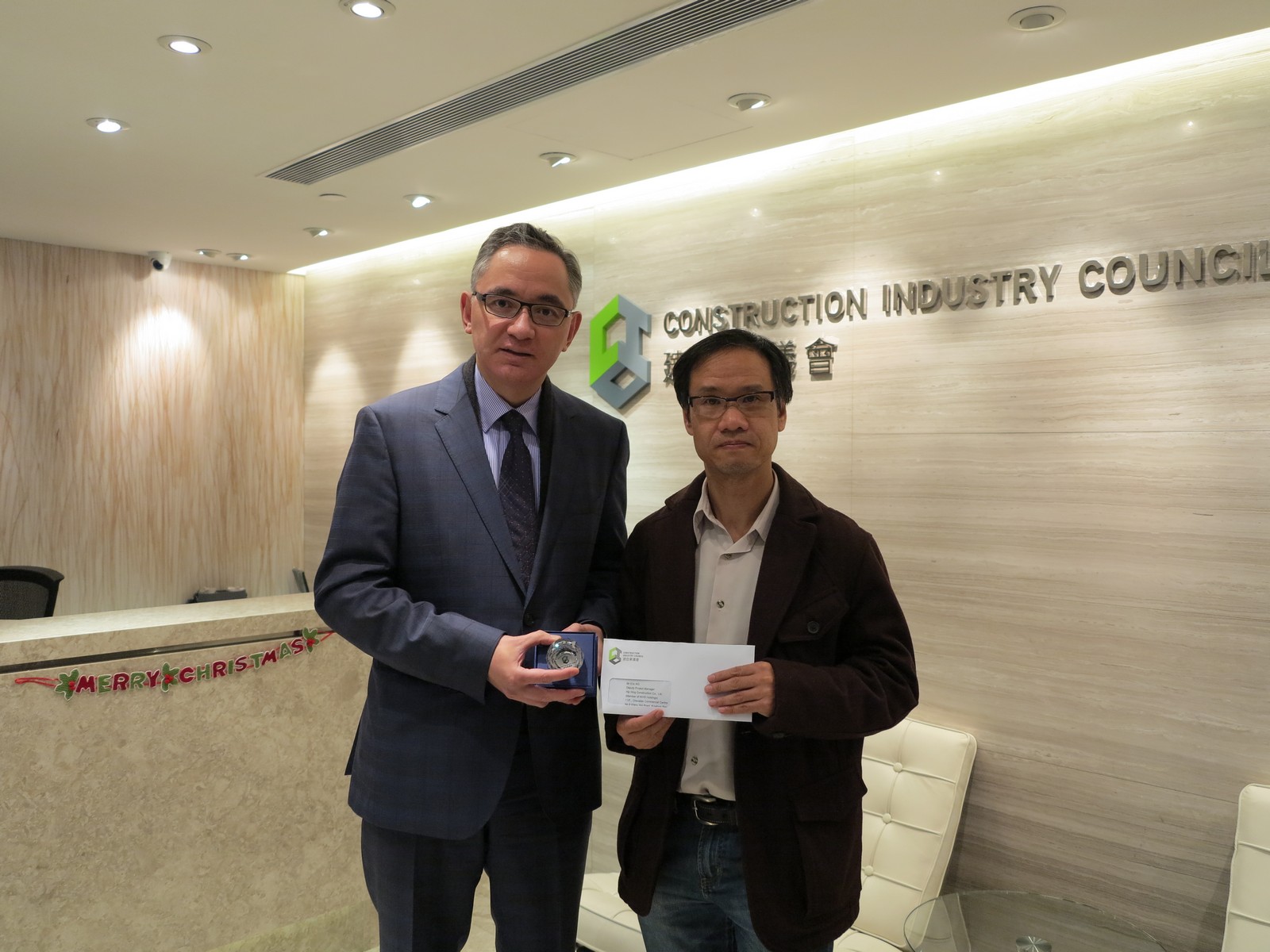 Souvenir presentation to Mr Eric Ng (right) , Deputy Project Manager of Hip Hing Construction by Mr Christopher To (left), Executive Director of the Construction Industry Council
